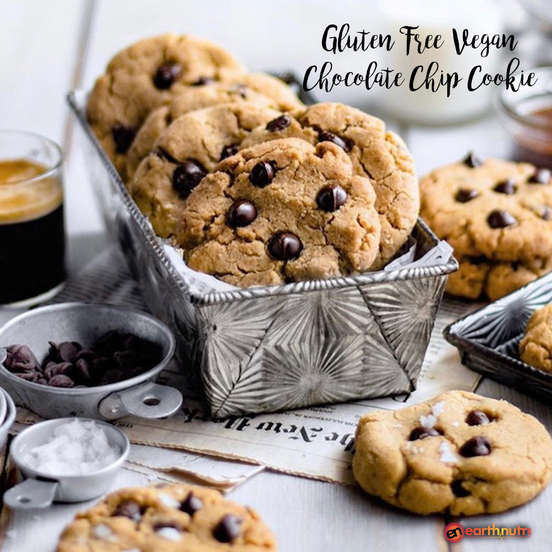 Gluten-free vegan chocolate chip cookies in a decorative metal container, surrounded by chocolate chips and small bowls of ingredients on a light tabletop, with text overlay.