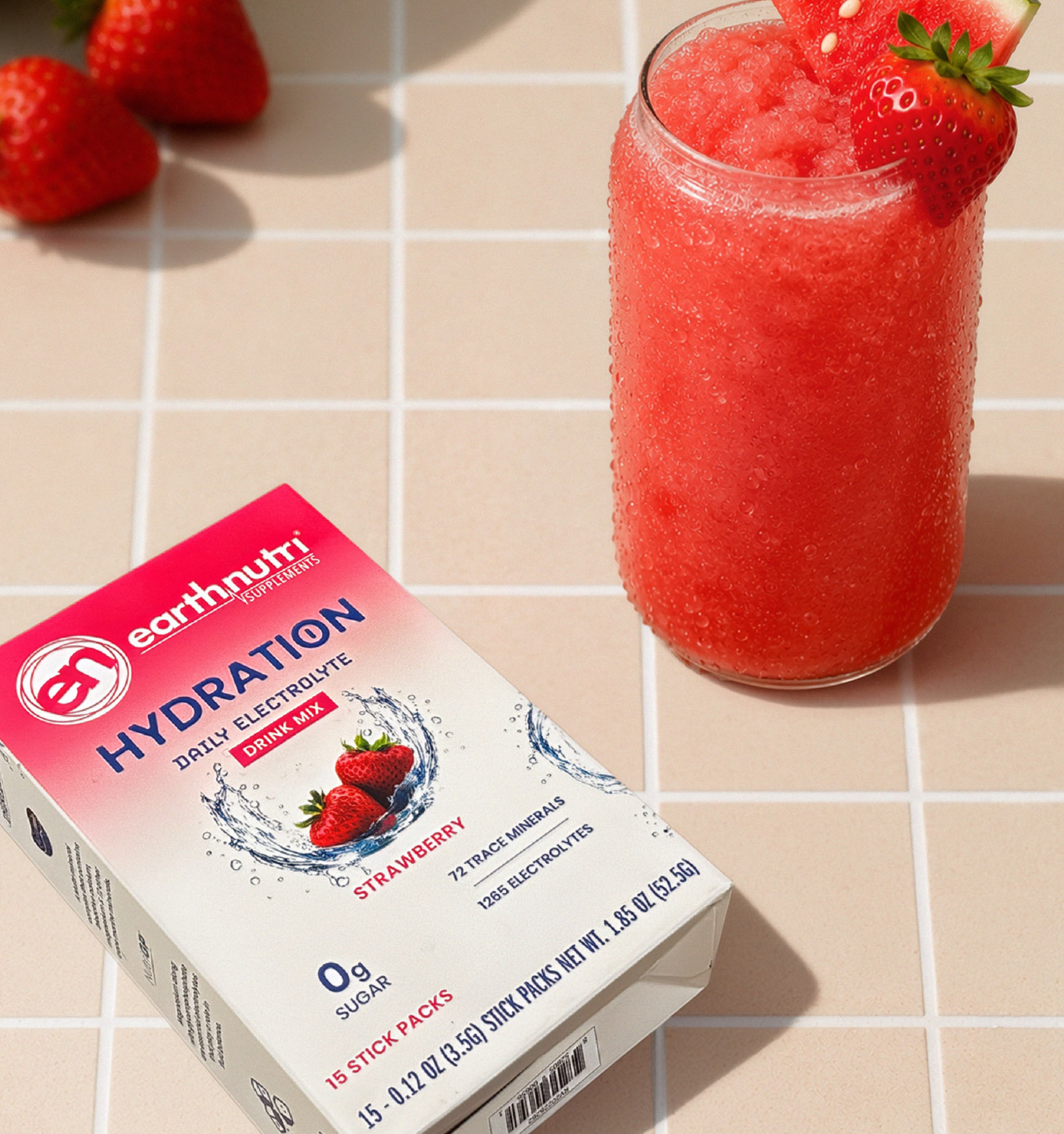 Earthnutri Hydration self-electrolyte drink mix in strawberry flavor, shown with its retail box and a glass of the pink-red watermelon slushy beverage garnished with a strawberry and watermelon slice on a tiled surface.