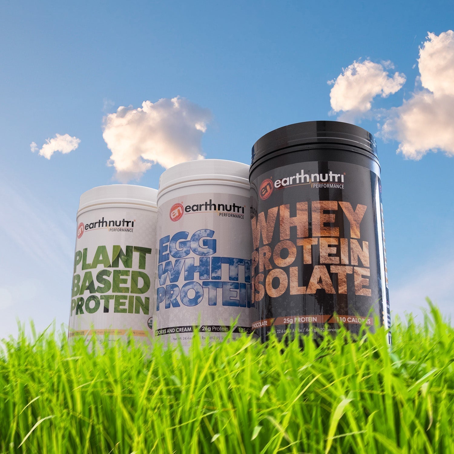 Three EarthNutri protein containers—plant-based, egg white, and whey isolate—displayed in green grass under a blue sky with clouds.