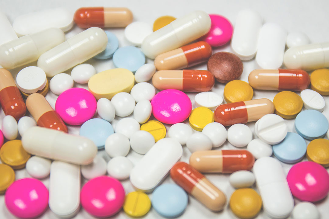 Assortment of colorful pills and capsules scattered across a surface.