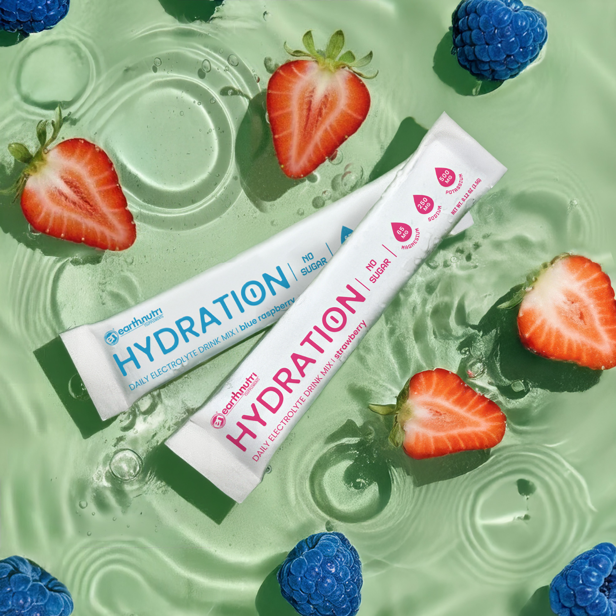 Two 'Hydration' tubes surrounded by sliced strawberries and blueberries on a green water background