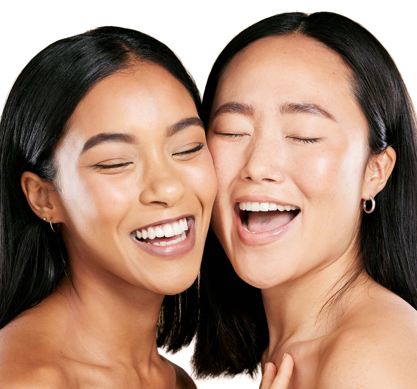 Two women smiling and laughing  together with their faces pressed up next to each other.