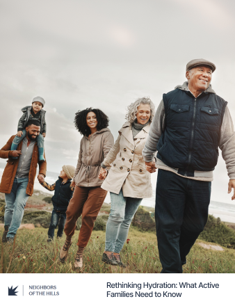 Family of six walking together in a field with a clear sky.